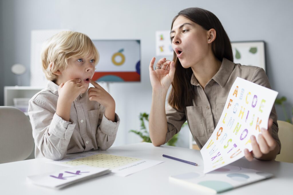 Speech Pathologist doing speech therapy with little blonde boy - Advantage Therapy