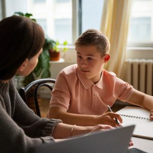 woman-helping-boy-with-homework-side-view_23-2149531835